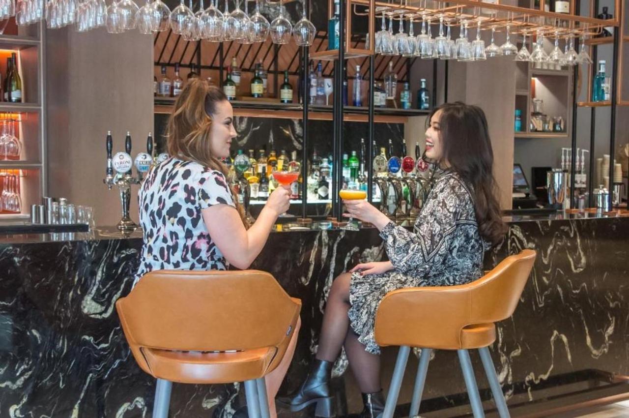 Clayton Hotel Manchester City Centre 외부 사진 Two women talking while having drinks at a bar